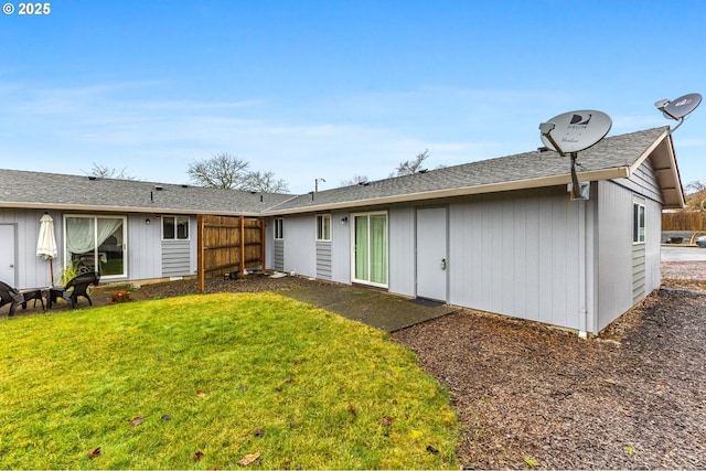 rear view of property featuring a lawn