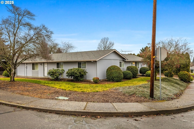 ranch-style home featuring a shingled roof and an attached garage