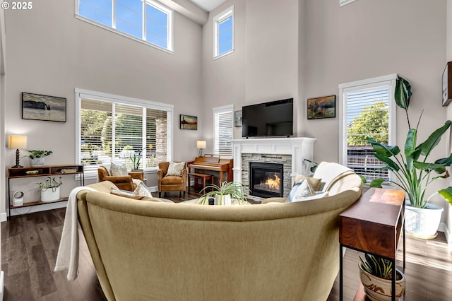 2625 NE 8th Ave, Battle Ground, WA 98604 - living area featuring dark wood-style flooring, a high ceiling, a stone fireplace, and baseboards