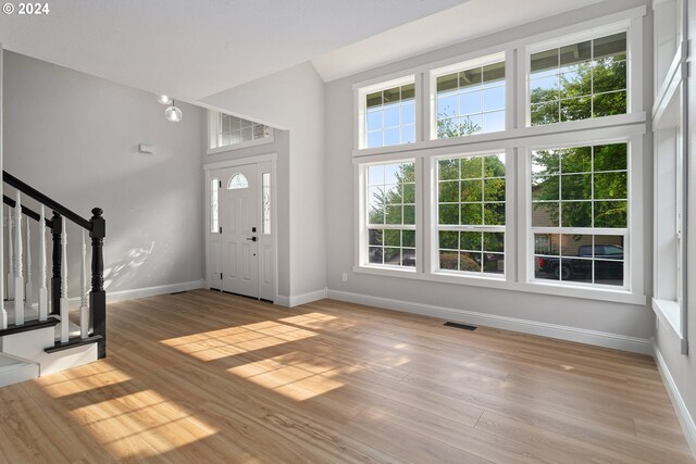 stairs featuring hardwood / wood-style flooring, a towering ceiling, and a notable chandelier