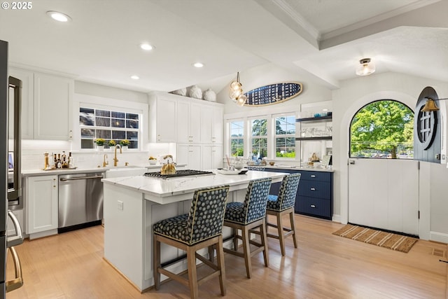 364 Northshore Rd, Lake Oswego, OR 97034 - kitchen with stainless steel appliances, decorative backsplash, a kitchen island, light wood-style flooring, and white cabinets
