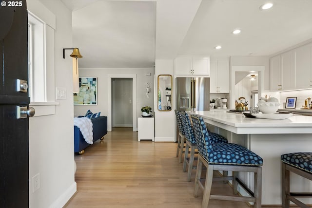 364 Northshore Rd, Lake Oswego, OR 97034 - kitchen featuring white cabinetry, a breakfast bar area, light wood-type flooring, light countertops, and stainless steel fridge