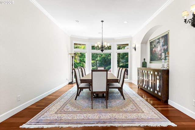 dining area with plenty of natural light, a chandelier, crown molding, dark wood finished floors, and baseboards