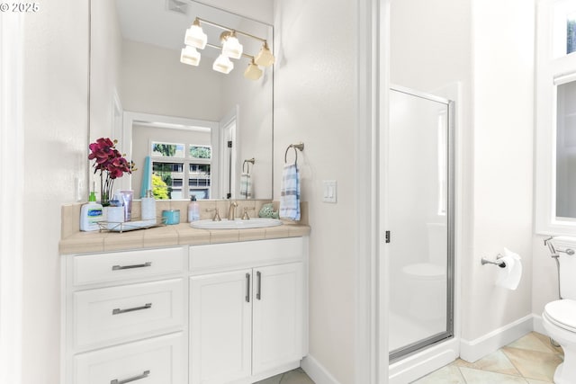bathroom with toilet, a stall shower, tile patterned flooring, vanity, and baseboards