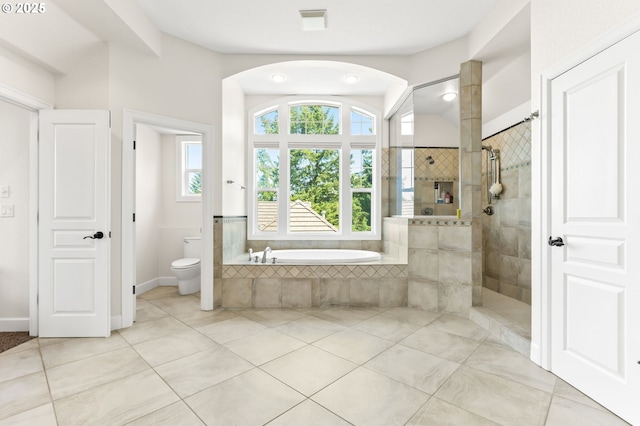 full bathroom with a tile shower, tile patterned floors, a bath, and toilet