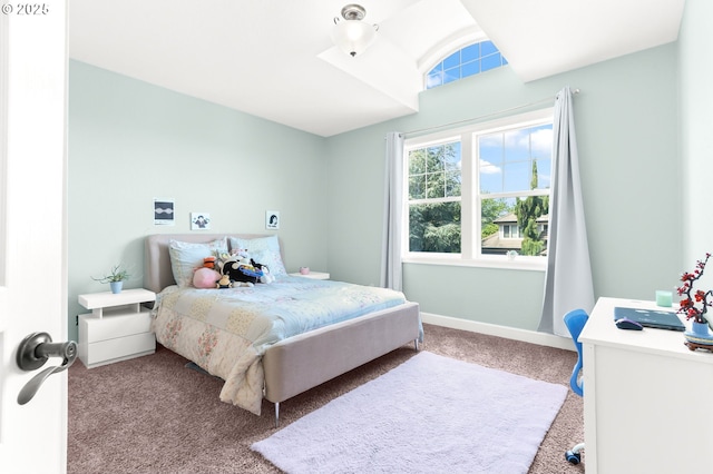 carpeted bedroom featuring lofted ceiling and baseboards