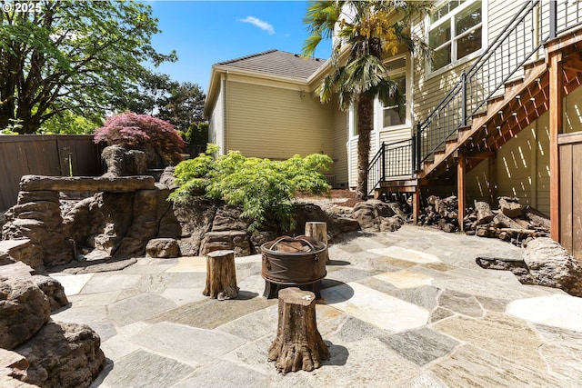 view of patio / terrace with stairway, fence, and an outdoor fire pit