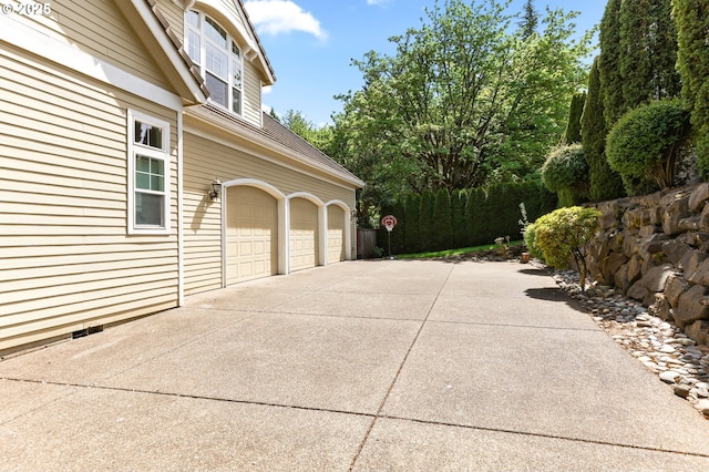 garage featuring concrete driveway