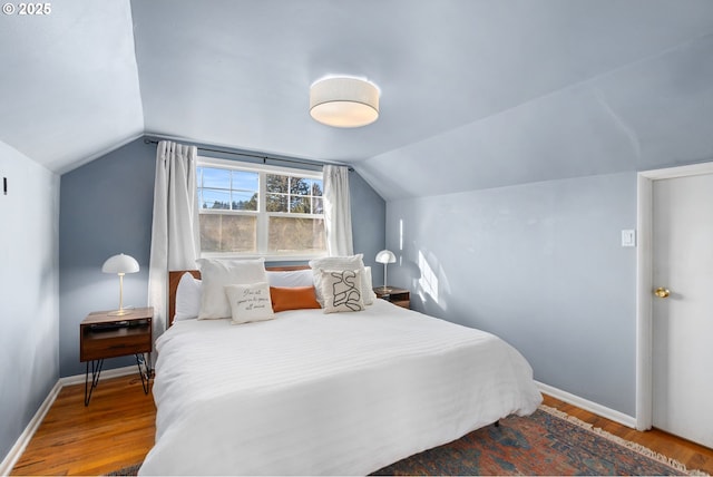 bedroom featuring hardwood / wood-style flooring and vaulted ceiling