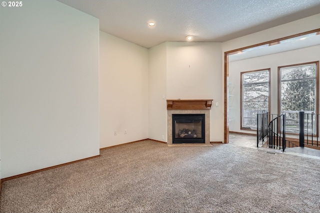 1207 NE 2nd Cir, Battle Ground, WA 98604 - unfurnished living room featuring baseboards, recessed lighting, a tiled fireplace, a textured ceiling, and carpet floors