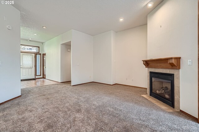 1207 NE 2nd Cir, Battle Ground, WA 98604 - unfurnished living room with a textured ceiling, recessed lighting, carpet flooring, a tile fireplace, and baseboards