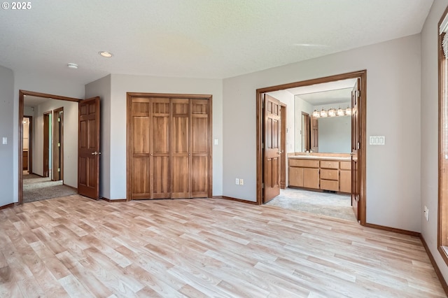 1207 NE 2nd Cir, Battle Ground, WA 98604 - unfurnished bedroom featuring a closet, baseboards, light wood-type flooring, and connected bathroom