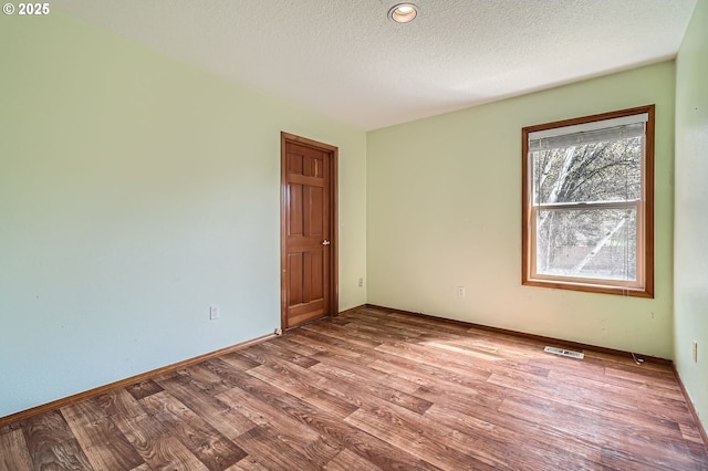1207 NE 2nd Cir, Battle Ground, WA 98604 - empty room featuring visible vents, baseboards, wood finished floors, and a textured ceiling