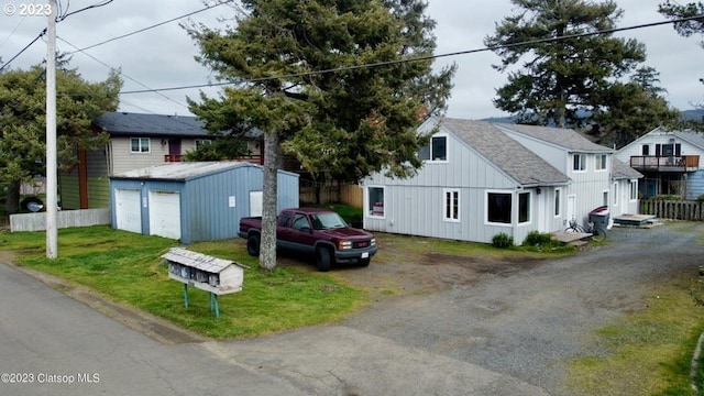 view of front facade with a garage, an outdoor structure, and a front lawn