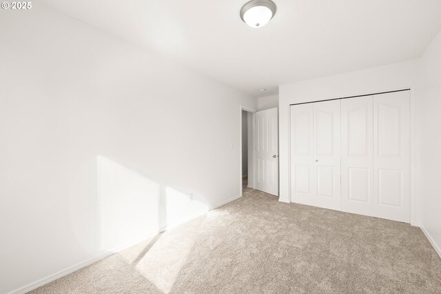 unfurnished bedroom with carpet flooring and a closet