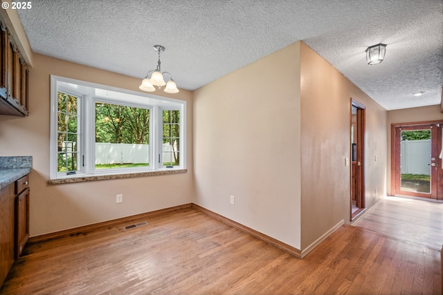 5807 NE 152nd Ave, Vancouver, WA 98682 - unfurnished dining area with plenty of natural light, light wood-type flooring, a textured ceiling, and a chandelier