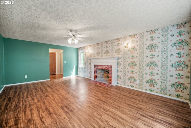 5807 NE 152nd Ave, Vancouver, WA 98682 - unfurnished living room featuring wood finished floors, a brick fireplace, a ceiling fan, a textured ceiling, and wallpapered walls