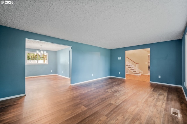 5807 NE 152nd Ave, Vancouver, WA 98682 - spare room featuring a chandelier, stairs, a textured ceiling, and wood finished floors