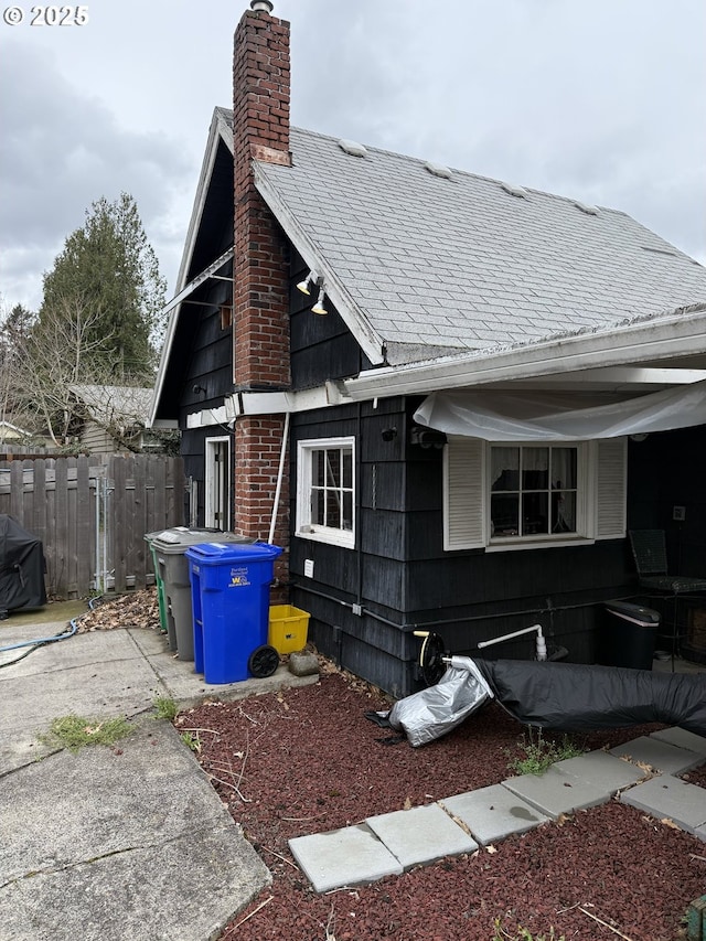 829 NE 107th Ave, Portland, OR 97220 - view of side of property featuring a chimney and roof with shingles