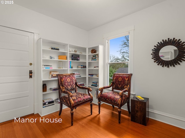 living area with baseboards and wood finished floors