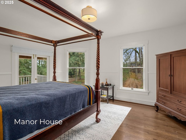 bedroom featuring multiple windows, access to exterior, and dark wood-style flooring