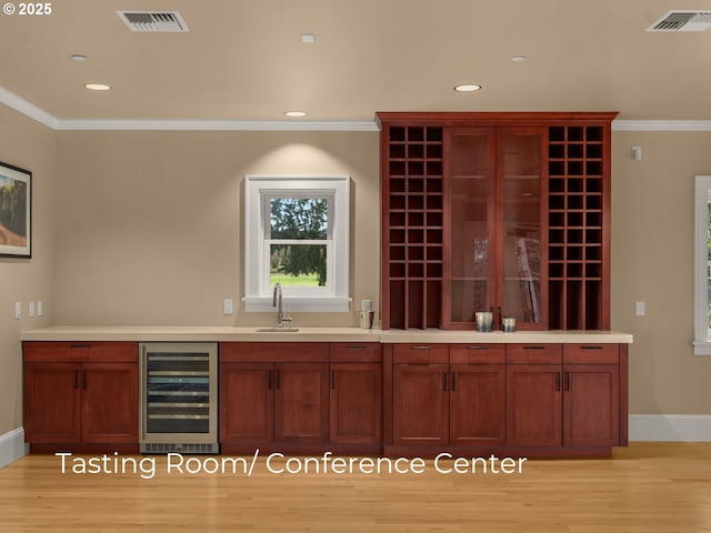 interior space with wine cooler, visible vents, and crown molding