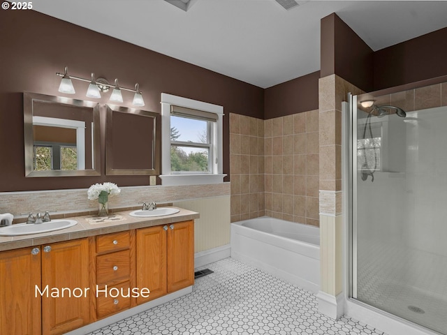 bathroom with a bath, a stall shower, double vanity, and a sink