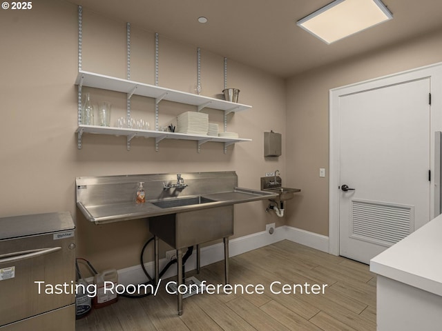 office with a sink, visible vents, baseboards, and light wood-style flooring