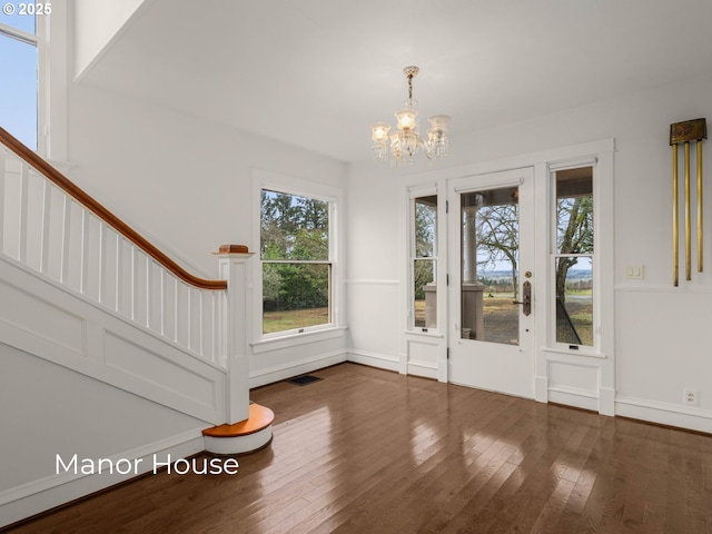 interior space with visible vents, baseboards, stairway, an inviting chandelier, and hardwood / wood-style flooring