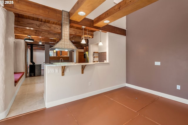 827 Tyler Creek Rd, Ashland, OR 97520 - kitchen with beamed ceiling, light tile patterned flooring, hanging light fixtures, a breakfast bar area, and a peninsula