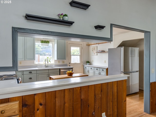 486 S Knott St, Canby, OR 97013 - kitchen featuring freestanding refrigerator, light countertops, light wood-style floors, and stainless steel dishwasher