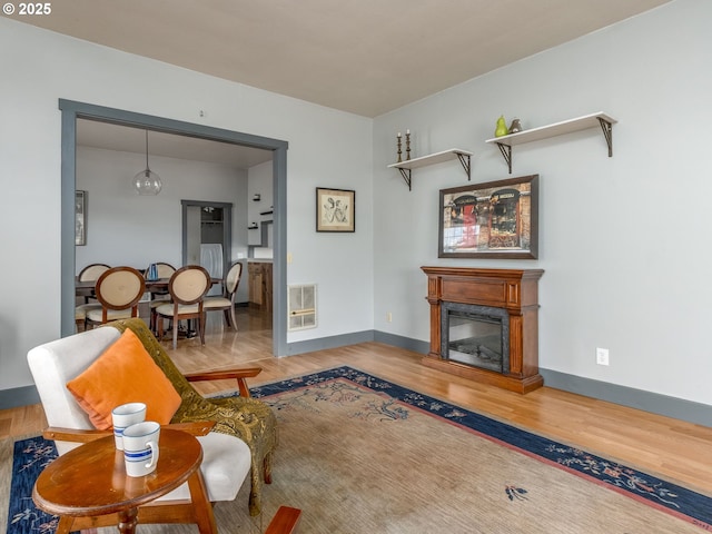 486 S Knott St, Canby, OR 97013 - living room featuring wood finished floors, heating unit, and a glass covered fireplace