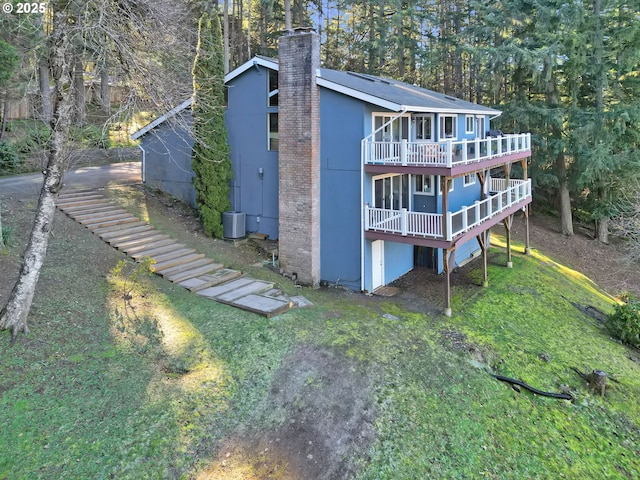 back of house featuring a wooden deck and a lawn