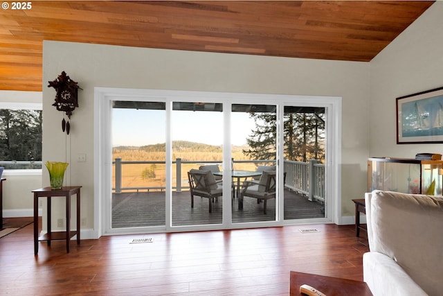 doorway to outside featuring visible vents, wood finished floors, a wealth of natural light, and lofted ceiling