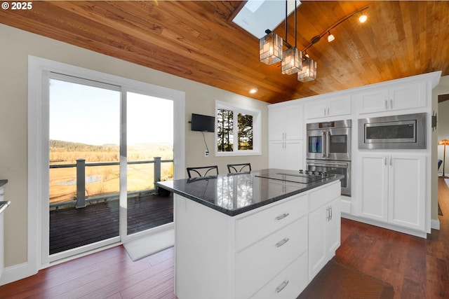 kitchen with dark wood finished floors, stainless steel appliances, wood ceiling, a kitchen island, and dark stone countertops