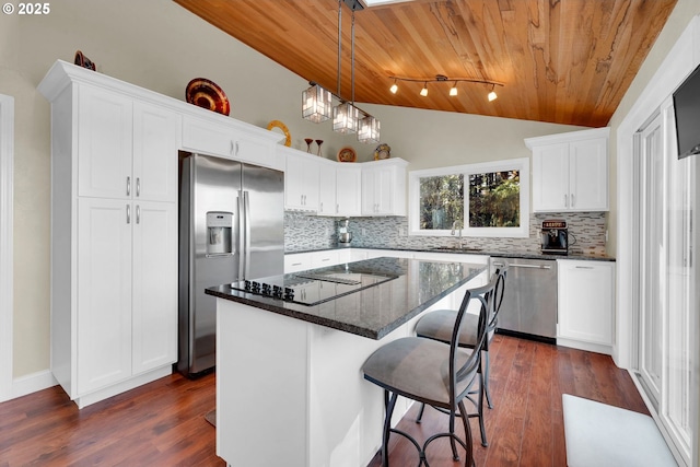 kitchen with white cabinets, wood ceiling, a kitchen island, vaulted ceiling, and stainless steel appliances