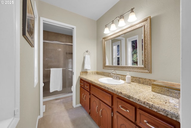 full bath featuring toilet, vanity, and a shower stall