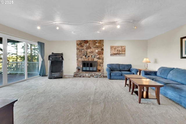 living area with carpet floors, a fireplace, rail lighting, and baseboards