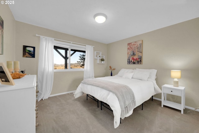 bedroom featuring light colored carpet and baseboards