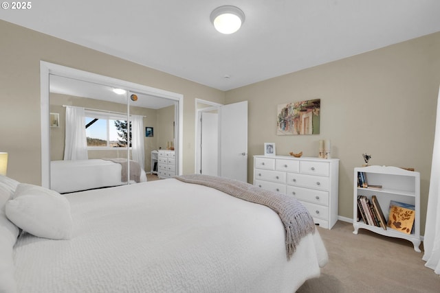 bedroom featuring light carpet and baseboards