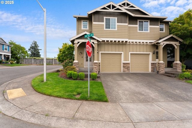 813 NW 1st Ave, Canby, OR 97013 - view of front of home featuring board and batten siding, driveway, an attached garage, and stone siding