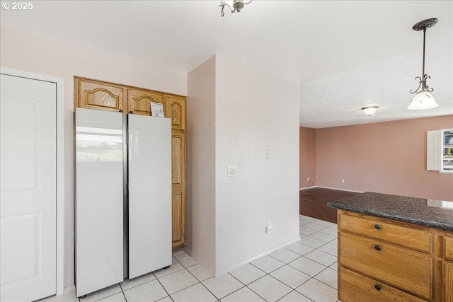 1825 Minnesota St, The Dalles, OR 97058 - kitchen featuring light tile patterned flooring, hanging light fixtures, freestanding refrigerator, open floor plan, and baseboards