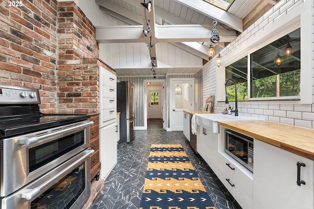 988 Savage Creek Rd, Grants Pass, OR 97527 - kitchen featuring stainless steel appliances, butcher block counters, white cabinets, a sink, and a skylight