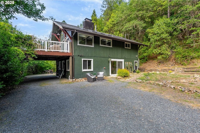 988 Savage Creek Rd, Grants Pass, OR 97527 - view of front of house with a chimney, a deck, driveway, and a carport