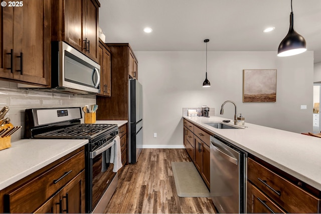 13009 NE 106th Cir, Vancouver, WA 98682 - kitchen with appliances with stainless steel finishes, a sink, dark wood-style floors, tasteful backsplash, and decorative light fixtures