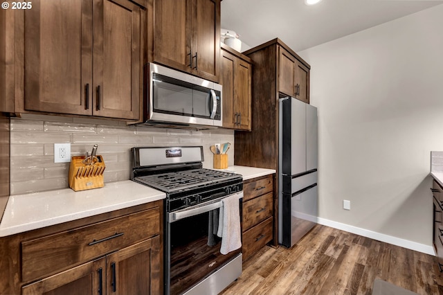 13009 NE 106th Cir, Vancouver, WA 98682 - kitchen with stainless steel appliances, baseboards, decorative backsplash, wood finished floors, and light countertops