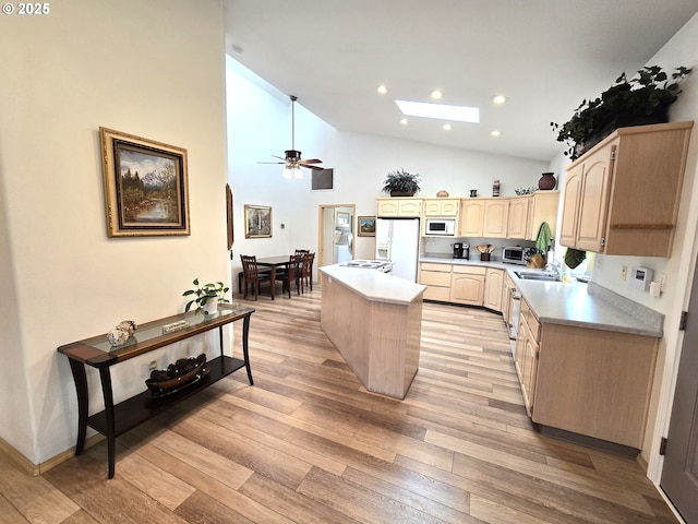 80393 Zimmer Ln, Hermiston, OR 97838 - kitchen featuring light brown cabinets, white appliances, a skylight, a center island, and light wood finished floors