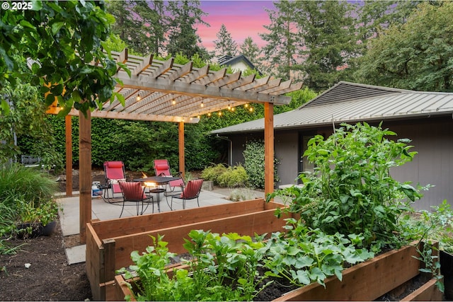 160 Iron Mountain Blvd, Lake Oswego, OR 97034 - patio terrace at dusk featuring a patio area, an outdoor fire pit, and a vegetable garden