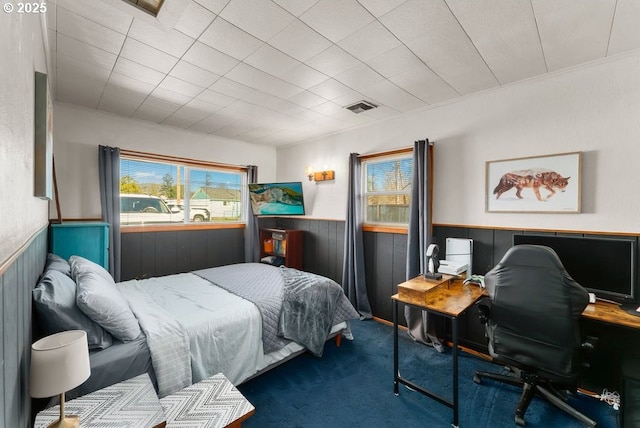 bedroom featuring a wainscoted wall, visible vents, and carpet floors