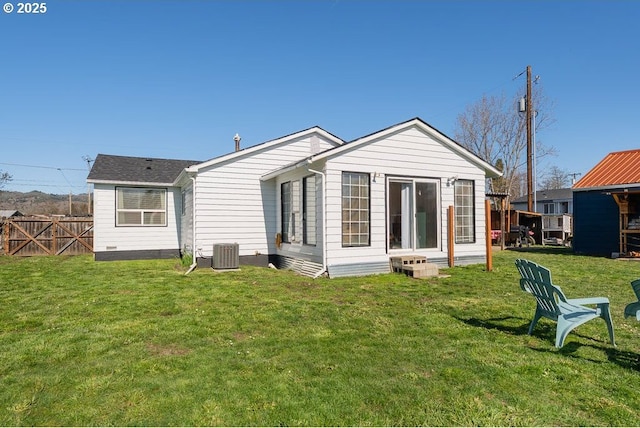 rear view of property with a lawn, central AC, and fence